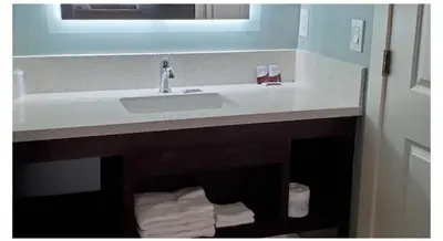 a bathroom counter with a sink and a mirror at Crestridge Inn Near LAX, SoFi Stadium & Intuit Dome in Inglewood