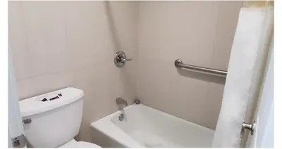 a white bathroom with a toilet and a sink at Crestridge Inn Near LAX, SoFi Stadium & Intuit Dome in Inglewood