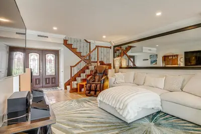 a living room with a white couch and a staircase at Chic Coastal Home with Outdoor Oasis in Oxnard! in Oxnard