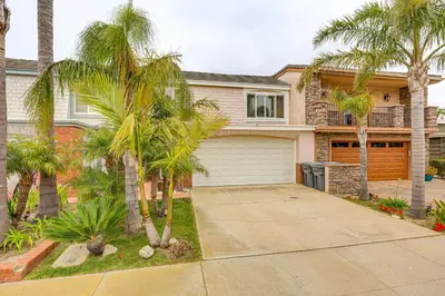 a house with palm trees in front of a driveway at Chic Coastal Home with Outdoor Oasis in Oxnard! in Oxnard