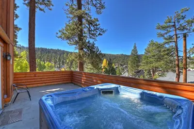 a jacuzzi tub on a deck with trees at Recreation Ridge-Next To Boulder Bay-HUGE in Big Bear Lake