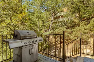 a grill sitting on a deck next to a fence at Bearfoot Lodge near Hiking & Skiing in Lake Arrowhead