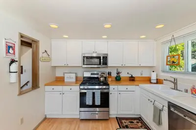 a kitchen with white cabinets and a stove top oven at Bow N Arrow Lodge For 8 in Lake Arrowhead