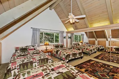 a bedroom with three beds and a ceiling at Bow N Arrow Lodge For 8 in Lake Arrowhead