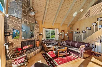 a living room with a couch and a fireplace at Bow N Arrow Lodge For 8 in Lake Arrowhead