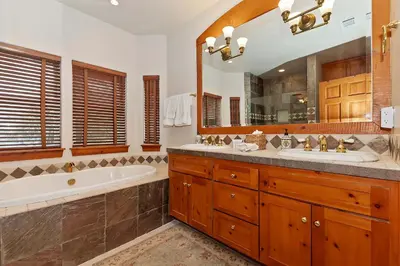 a bathroom with two sinks and a tub and a large mirror at Matternhorn Peak Lodge - For 10 in Lake Arrowhead