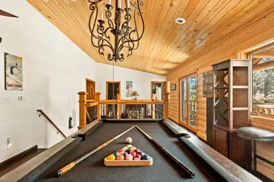 a pool table in a billiard room with a chandelier at Summit Pine Lodge - 2 Minutes to Snow Summit in Big Bear Lake