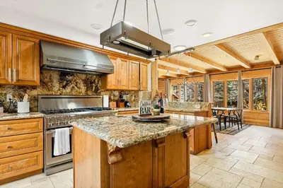 a kitchen with wooden cabinets and a stove top oven at Summit Pine Lodge - 2 Minutes to Snow Summit in Big Bear Lake