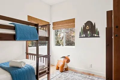 a bedroom with two bunk beds and a monkey picture on the wall at The Fancy Fox - Stunning 4 BR Retreat Close to Lake in Lake Arrowhead