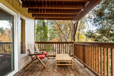 a porch with two chairs and a table and a bench at The Fancy Fox - Stunning 4 BR Retreat Close to Lake in Lake Arrowhead