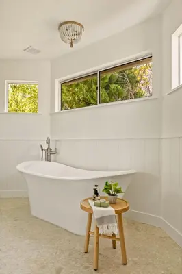 a white bathroom with a tub and a table at The Lilypad - 2 Master Bedrooms & Game Room in Lake Arrowhead
