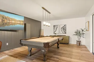 a room with a pool table and a large screen at The Lilypad - 2 Master Bedrooms & Game Room in Lake Arrowhead