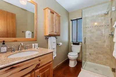 a bathroom with a sink and a toilet and a shower at Tres Patos - Lakefront Stay for 8 in Green Valley Lake