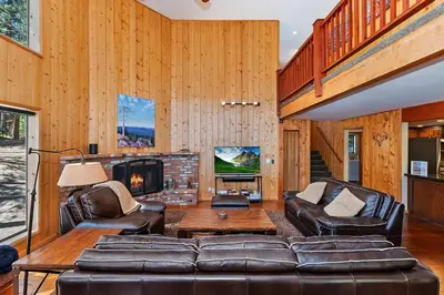 a living room with leather furniture and a fireplace at Tres Patos - Lakefront Stay for 8 in Green Valley Lake