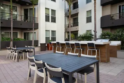 a patio with tables and chairs in front of a building at Blueground Venice pool AC nr beach LAX-1330 in Los Angeles