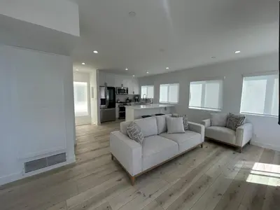 a living room with a couch and a kitchen at MB Modern Sand Section Sea View in Manhattan Beach