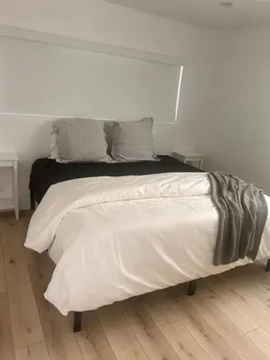 a white bedroom with a bed with white sheets and pillows at MB Modern Sand Section Sea View in Manhattan Beach