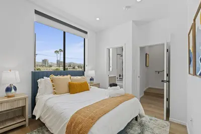 a bedroom with a large bed and a large window at Serene Hollywood in Los Angeles