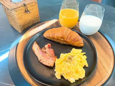 a plate of eggs and bacon and a glass of milk at Boy Travel in Hewitt