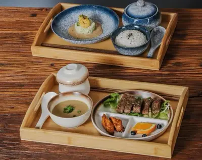 a wooden tray with two plates of food and a bowl of soup at Boy Travel in Hewitt