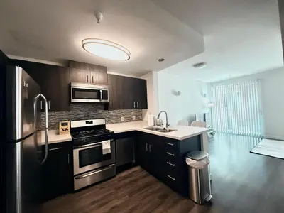 a kitchen with black cabinets and stainless steel appliances at Heart of Koreatwon, 1Bed Studio in Los Angeles