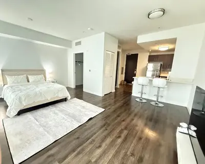 a white bedroom with a bed and a kitchen at Heart of Koreatwon, 1Bed Studio in Los Angeles