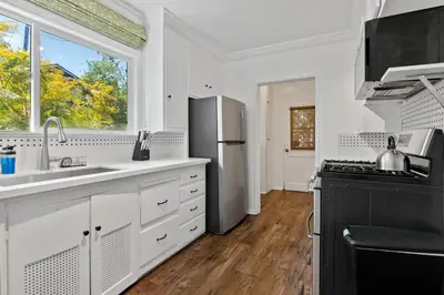 a kitchen with white cabinets and a black refrigerator at 4bed 3bath spacious modern piano home near Universal Studio and Hollywood for 10 in Studio City