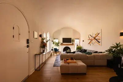 a living room with a couch and a table at Hauser House, Modern Artful Spanish-style Bungalow in Los Angeles
