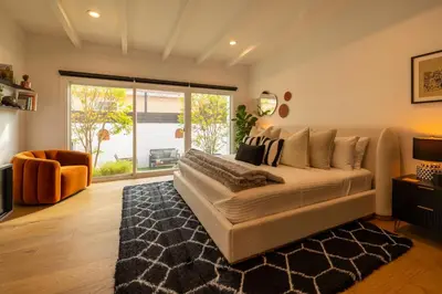 a bedroom with a large bed and a large window at Hauser House, Modern Artful Spanish-style Bungalow in Los Angeles
