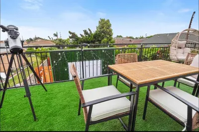 a camera and a table and chairs on a balcony at Twilight Terrace - Telescope - 15 Min to Beach in Hawthorne
