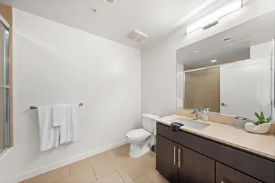 a bathroom with a sink and a toilet and a mirror at The Iris-Modern 3BD in the Heart of Marina del Rey-Pool,Gym,Jacuzzi-Near LAX in Los Angeles