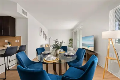 a dining room with a table and blue chairs at The Iris-Modern 3BD in the Heart of Marina del Rey-Pool,Gym,Jacuzzi-Near LAX in Los Angeles