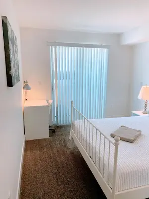 a white bedroom with a crib and a large window at Western and Santa Monica in Los Angeles