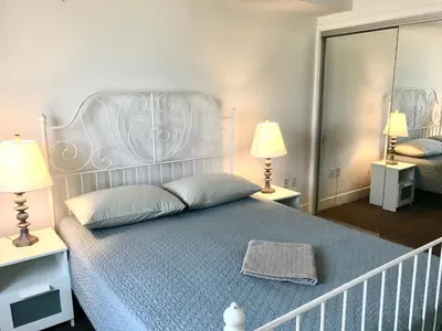 a bedroom with a bed with two lamps and a mirror at Western and Santa Monica in Los Angeles