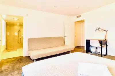 a bedroom with a couch and a desk in it at Western Santa Monica in Los Angeles