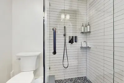a bathroom with a shower with a glass door at The Kingsview Lakehouse in Lake Arrowhead