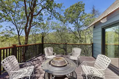 a patio with a table and chairs on a deck at The Kingsview Lakehouse in Lake Arrowhead
