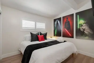 a bedroom with a large white bed with posters on the wall at Jedi Retreat-10mins to Disney-Hot Tub-Big Group in Anaheim
