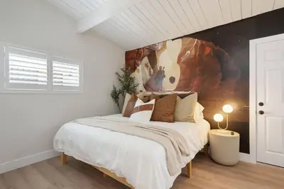 a bedroom with a bed with a painting on the wall at Jedi Retreat-10mins to Disney-Hot Tub-Big Group in Anaheim