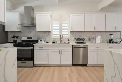 a kitchen with white cabinets and stainless steel appliances at Lightsaber Lounge-Hot Tub-Billiards-10mnstoDisney in Anaheim
