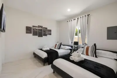 two beds in a room with white walls at Darth Vaders Lair - 10 mins to Disney - Sleeps 6 in Anaheim