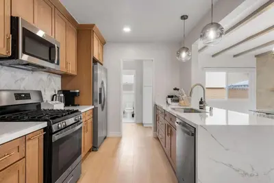 a kitchen with wooden cabinets and a stove top oven at Cascade Cove - Heated Pool Spa - Billiards and Lounge in Long Beach