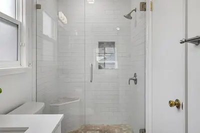a white bathroom with a shower and a toilet at Cascade Cove - Heated Pool Spa - Billiards and Lounge in Long Beach