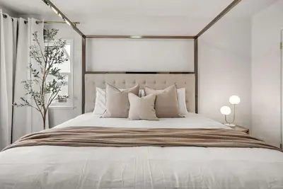 a bedroom with a large bed with white sheets and pillows at Cascade Cove - Heated Pool Spa - Billiards and Lounge in Long Beach