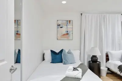 a bedroom with two beds with blue and white pillows at Modern Elegance- Big Group - Games - Sleeps 10 in Los Angeles