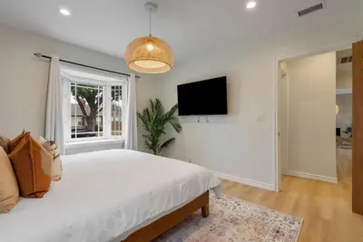 a bedroom with a bed and a flat screen tv at Stunning Retro Beach Oasis, Dual Living, Pool in Long Beach
