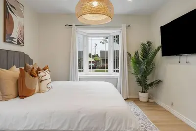 a bedroom with a large white bed and a window at Stunning Retro Beach Oasis, Dual Living, Pool in Long Beach