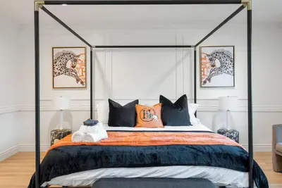 a bedroom with a canopy bed with orange and blue pillows at Designer Dream- Pool and spa- Game Room- Sleeps 10 in Los Angeles