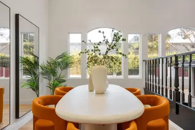 a white table and chairs in a room with windows at Designer Dream- Pool and spa- Game Room- Sleeps 10 in Los Angeles