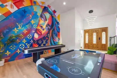a room with a painting of a woman at Designer Dream- Pool and spa- Game Room- Sleeps 10 in Los Angeles